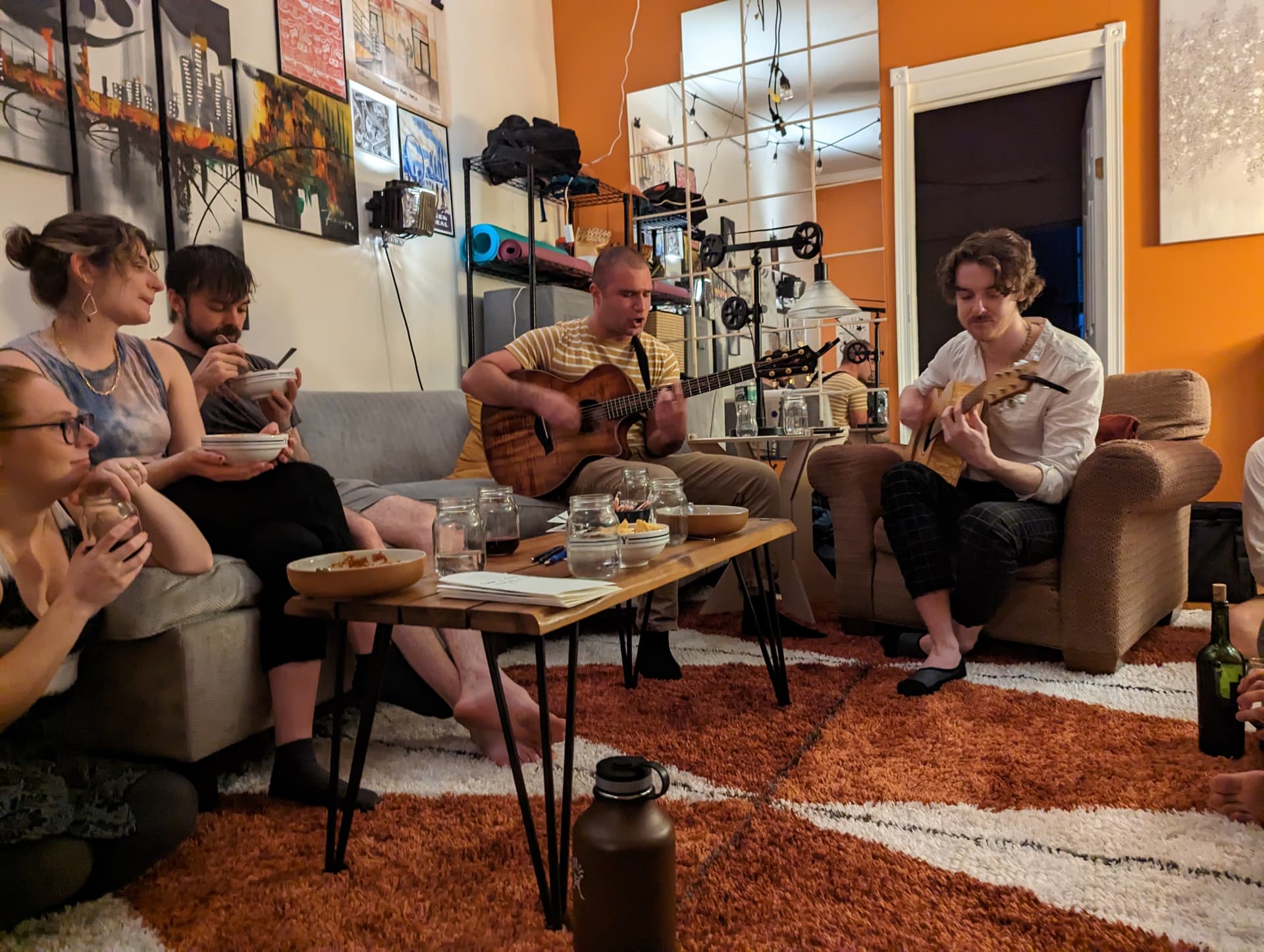 An evening at the first house — guitars, food, friends on couches
