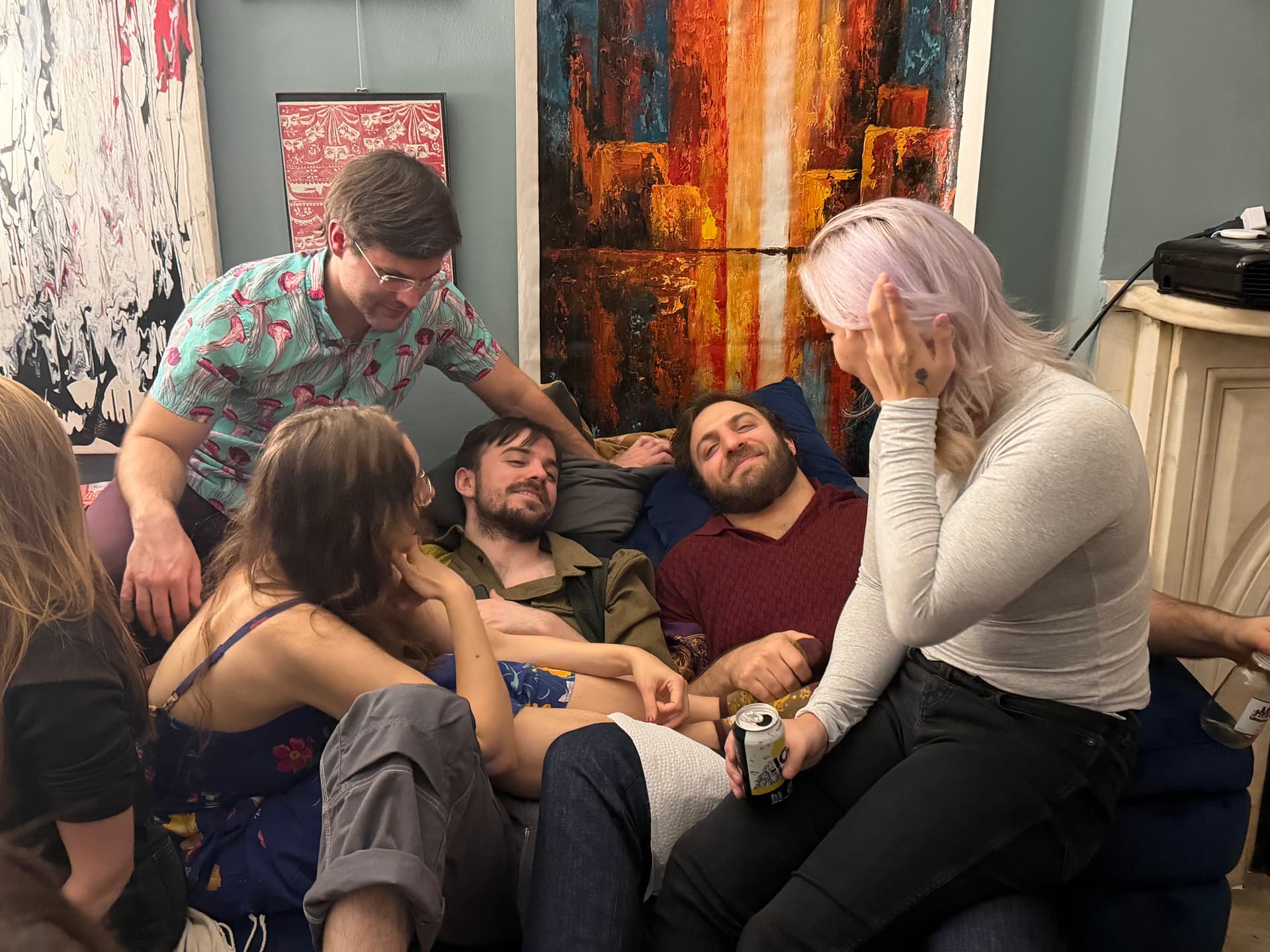 Friends piled together on a couch, laughing